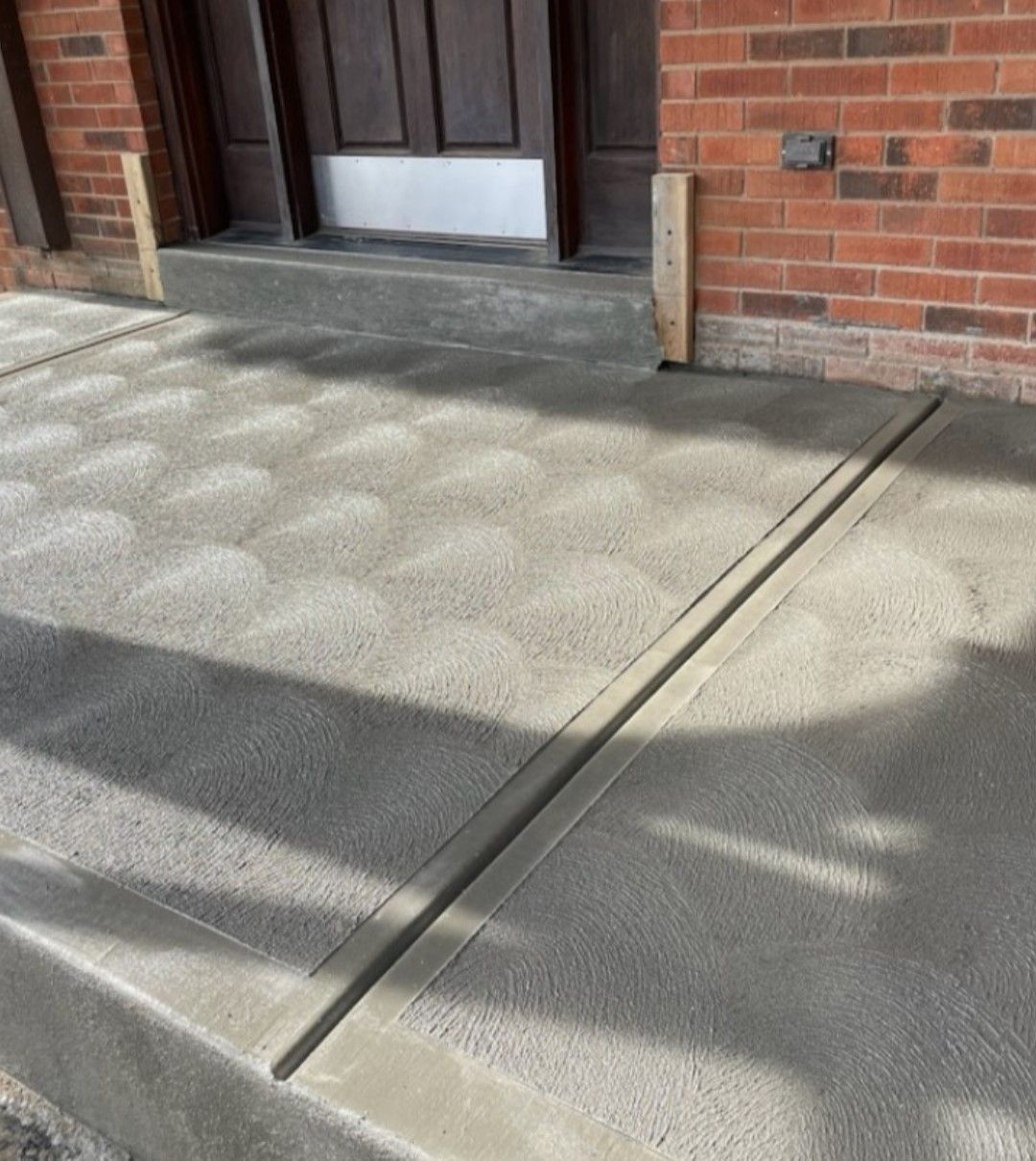 a brick building with a concrete walkway in front of it