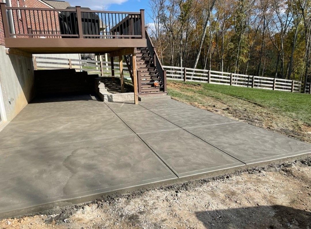 a concrete driveway with a deck underneath it