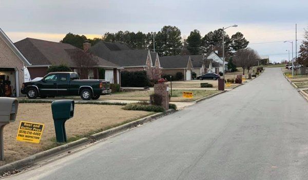 Residential street with houses and a truck parked in a driveway.