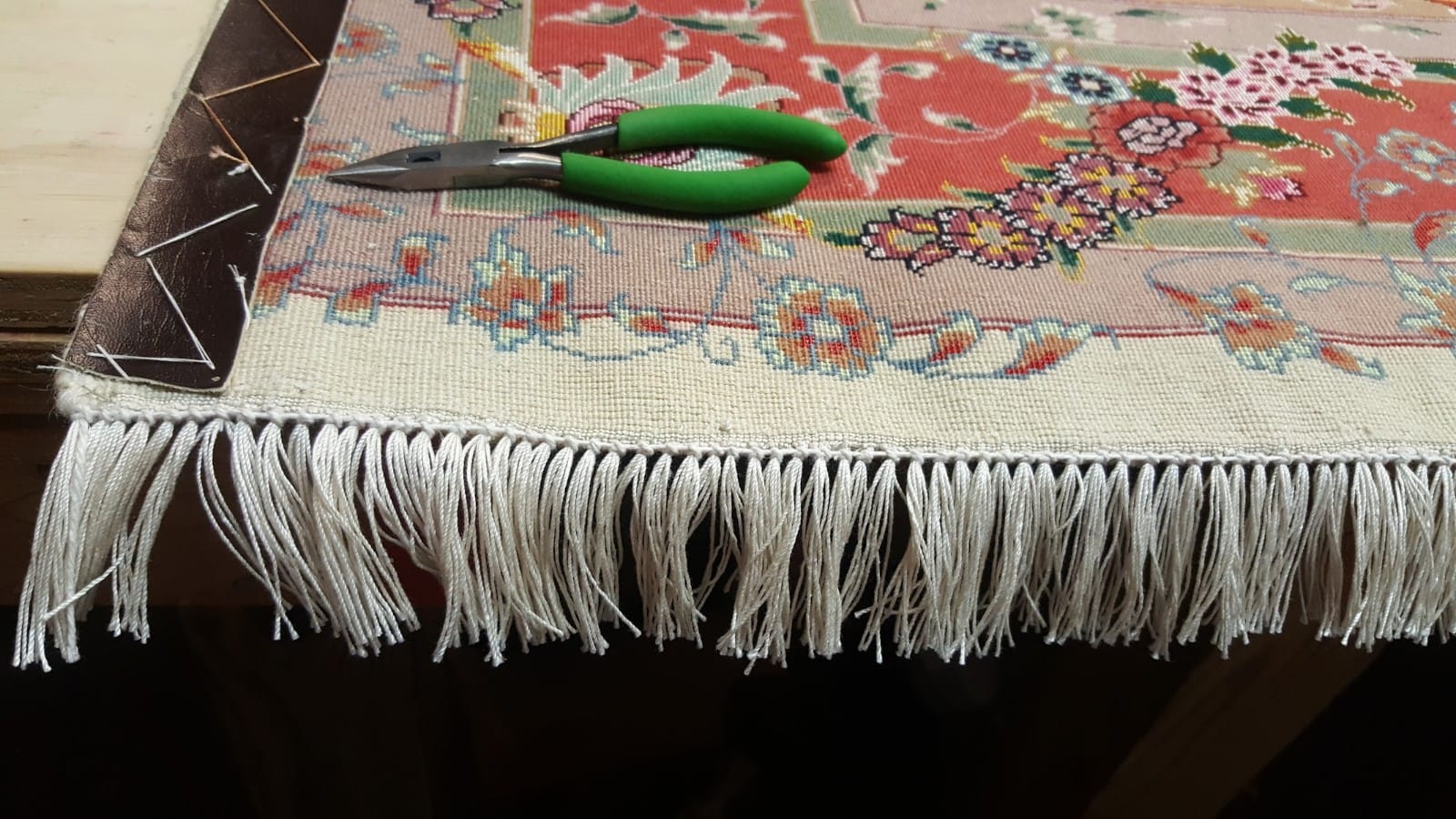 Closeup of rug with repair tools