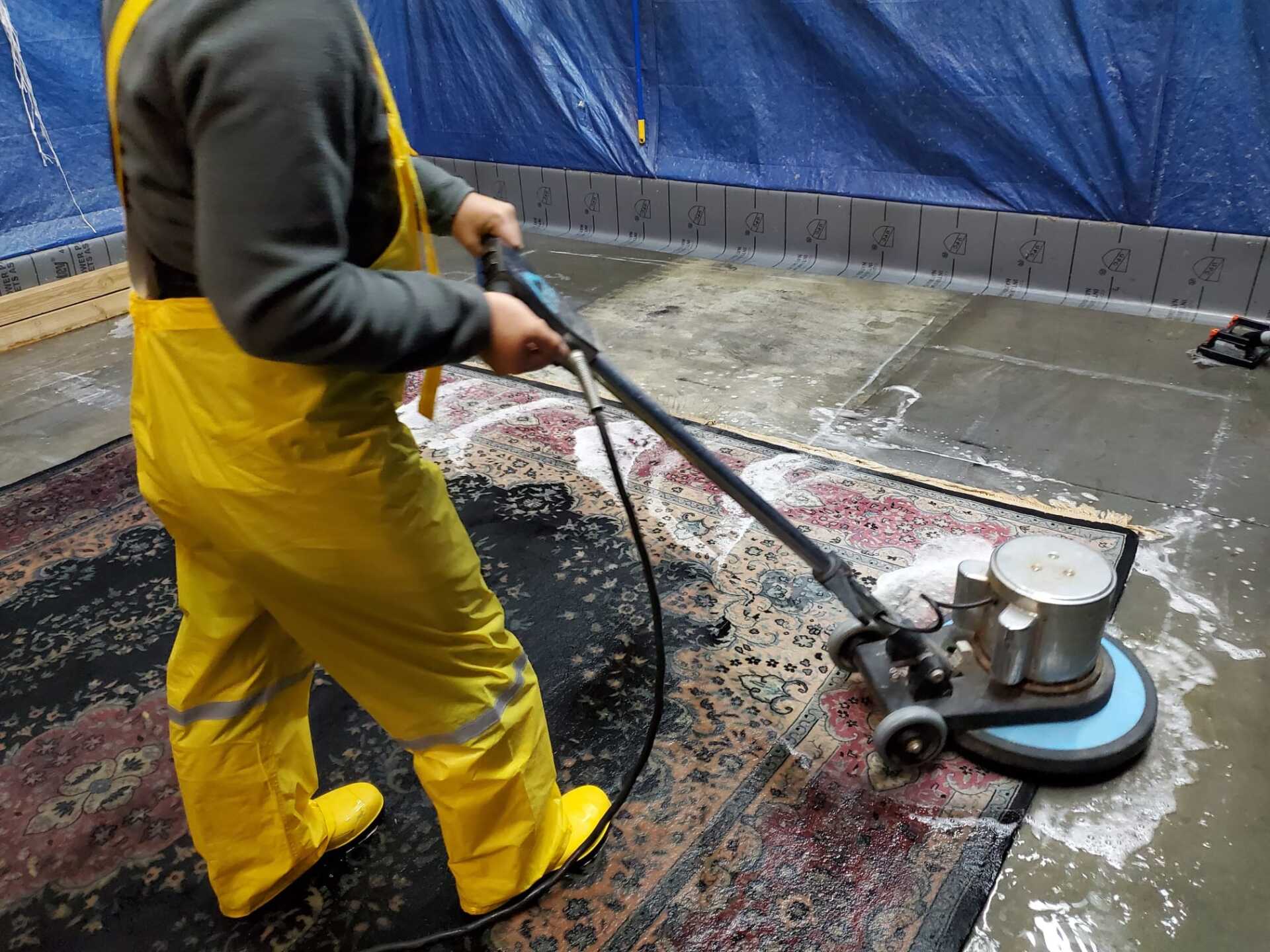 Dior LLC worker cleaning rug with machine