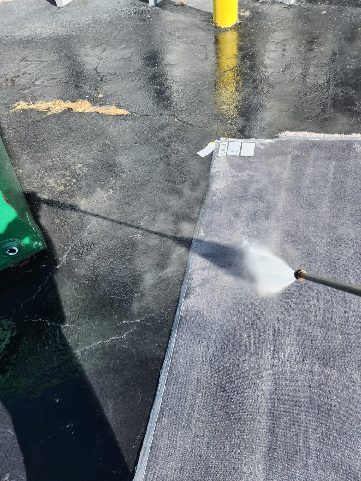 spraying the underside of the rug with water