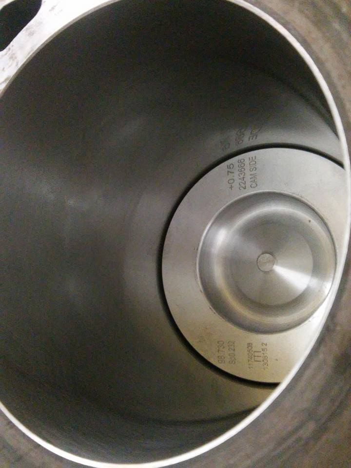 Inside view of a stainless steel trash can with a circular lid or drain at the bottom