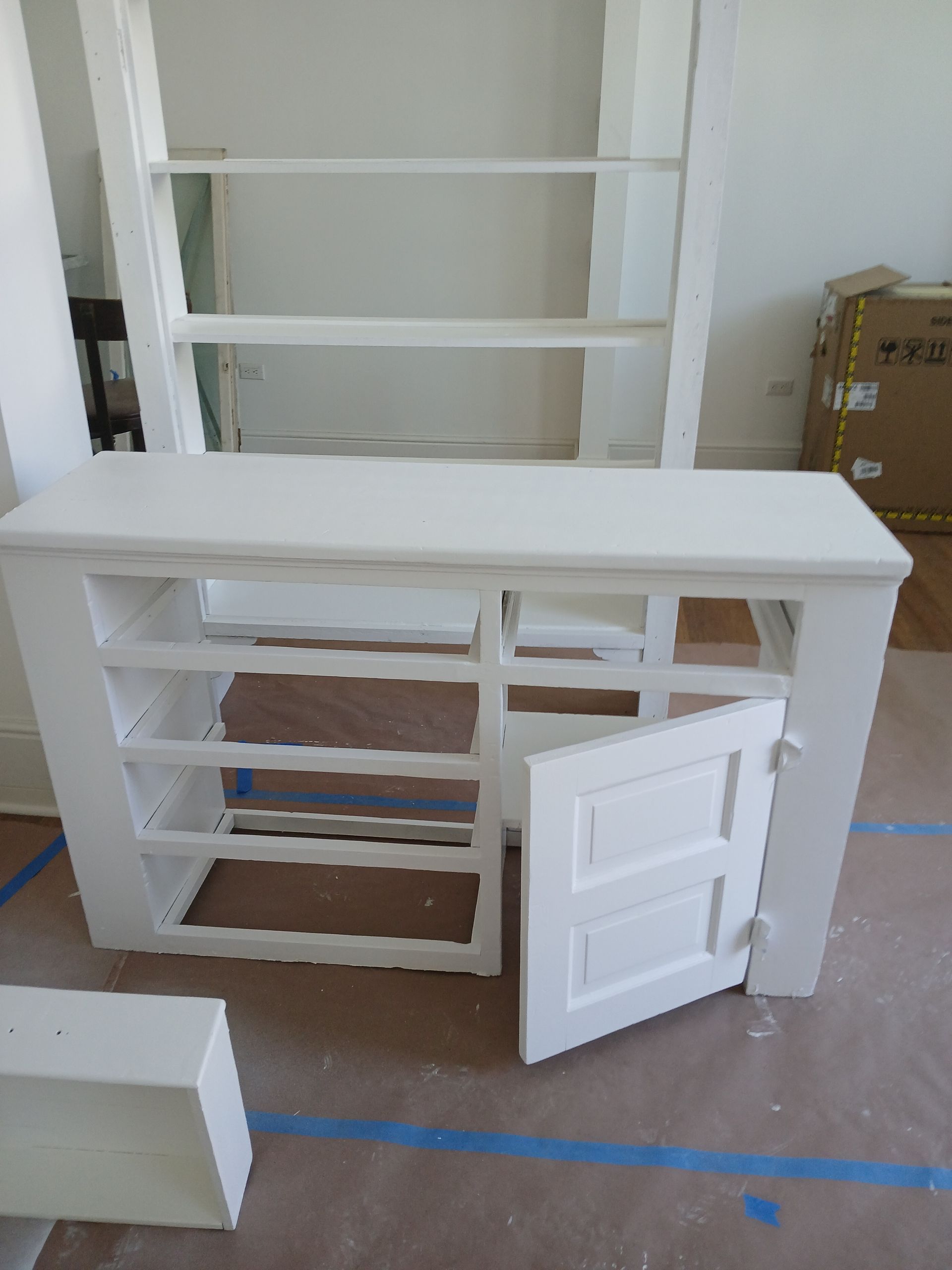 A white cabinet with a door open in a room.