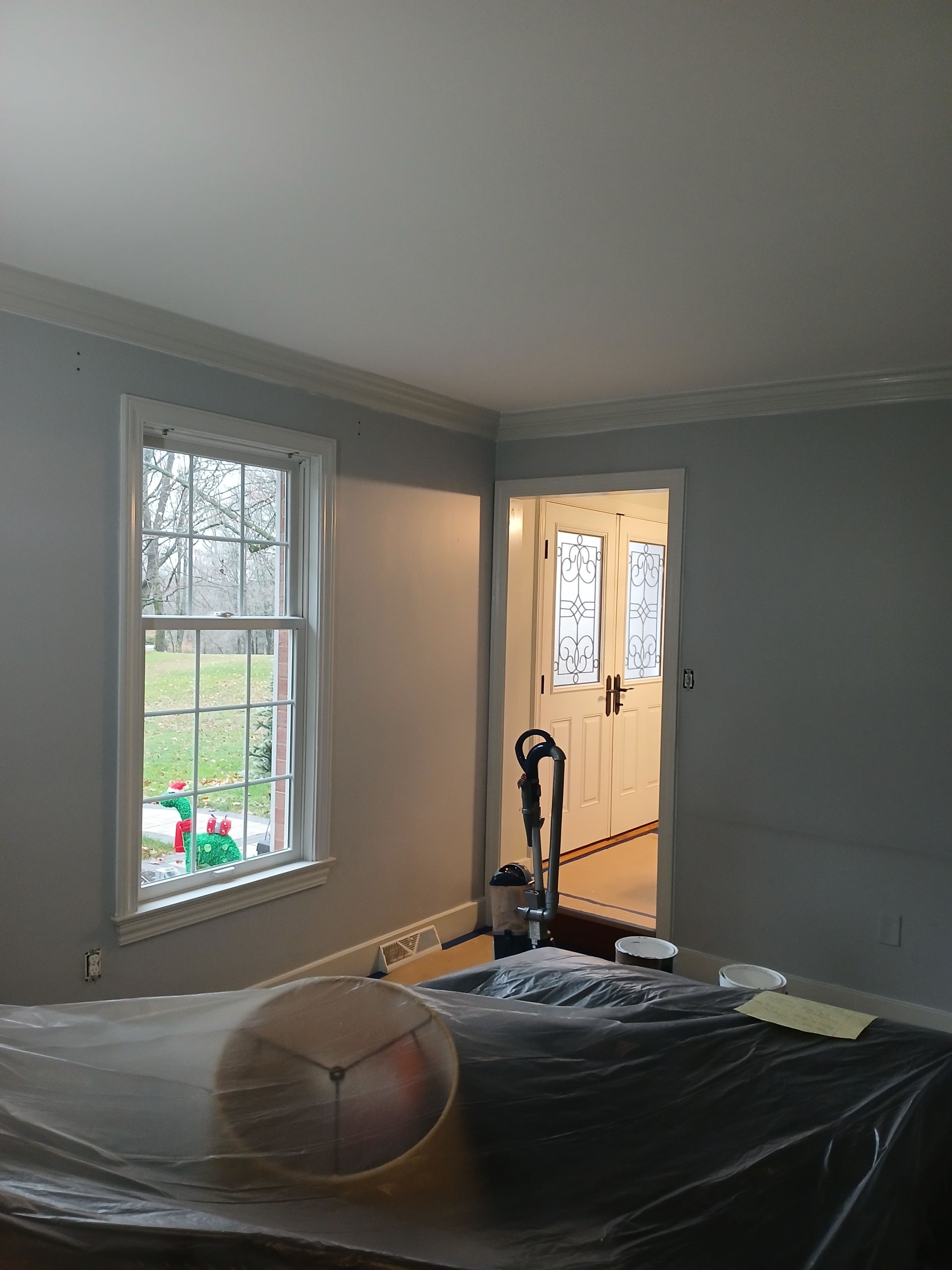 A room with a window and a door is being painted.