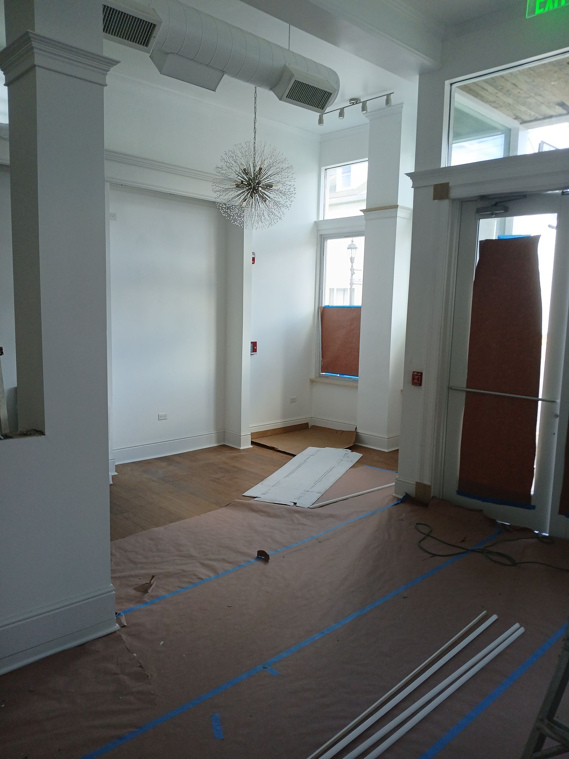 An empty room with a green exit sign on the wall