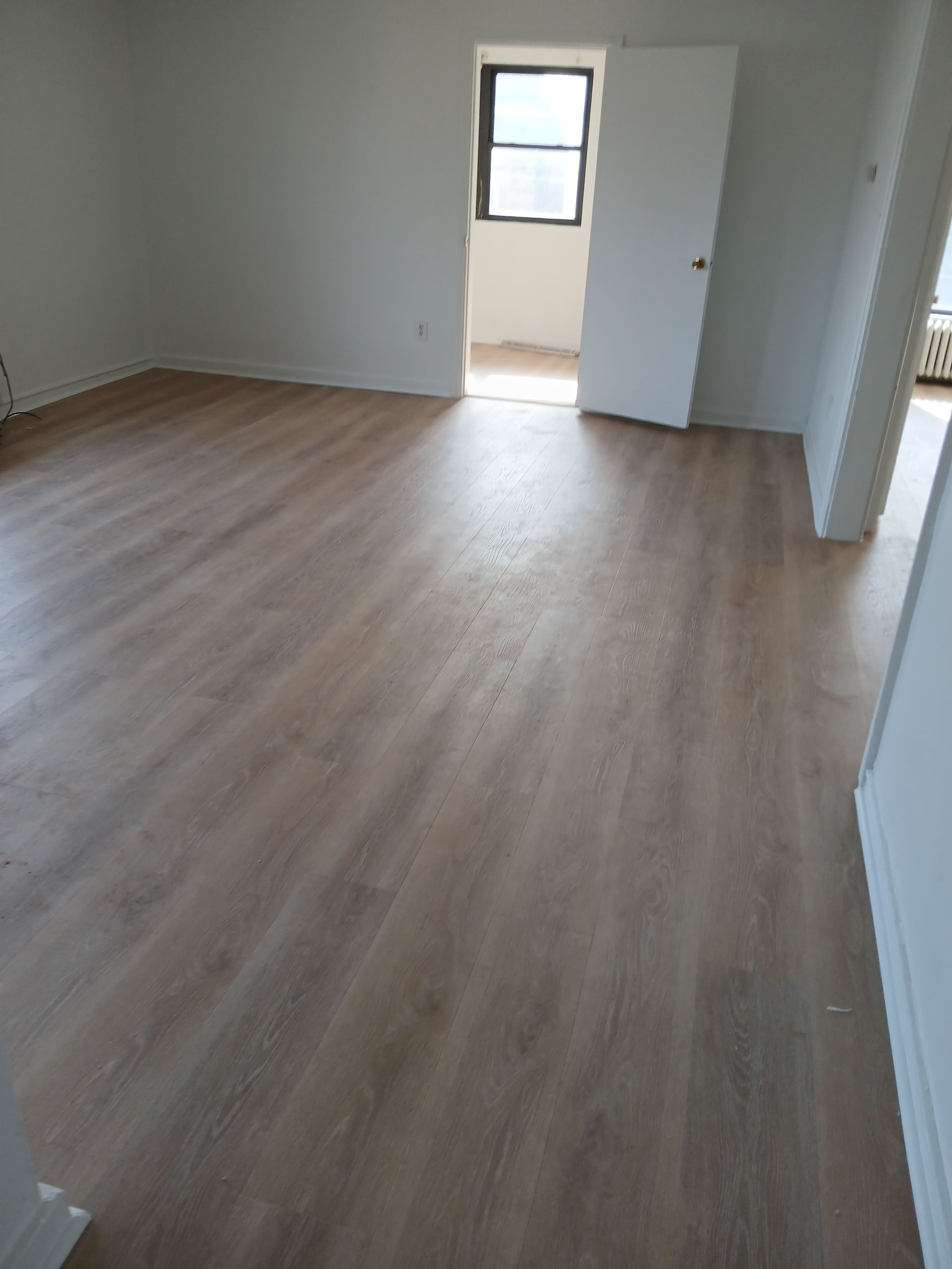 A room with a wooden floor and white walls.