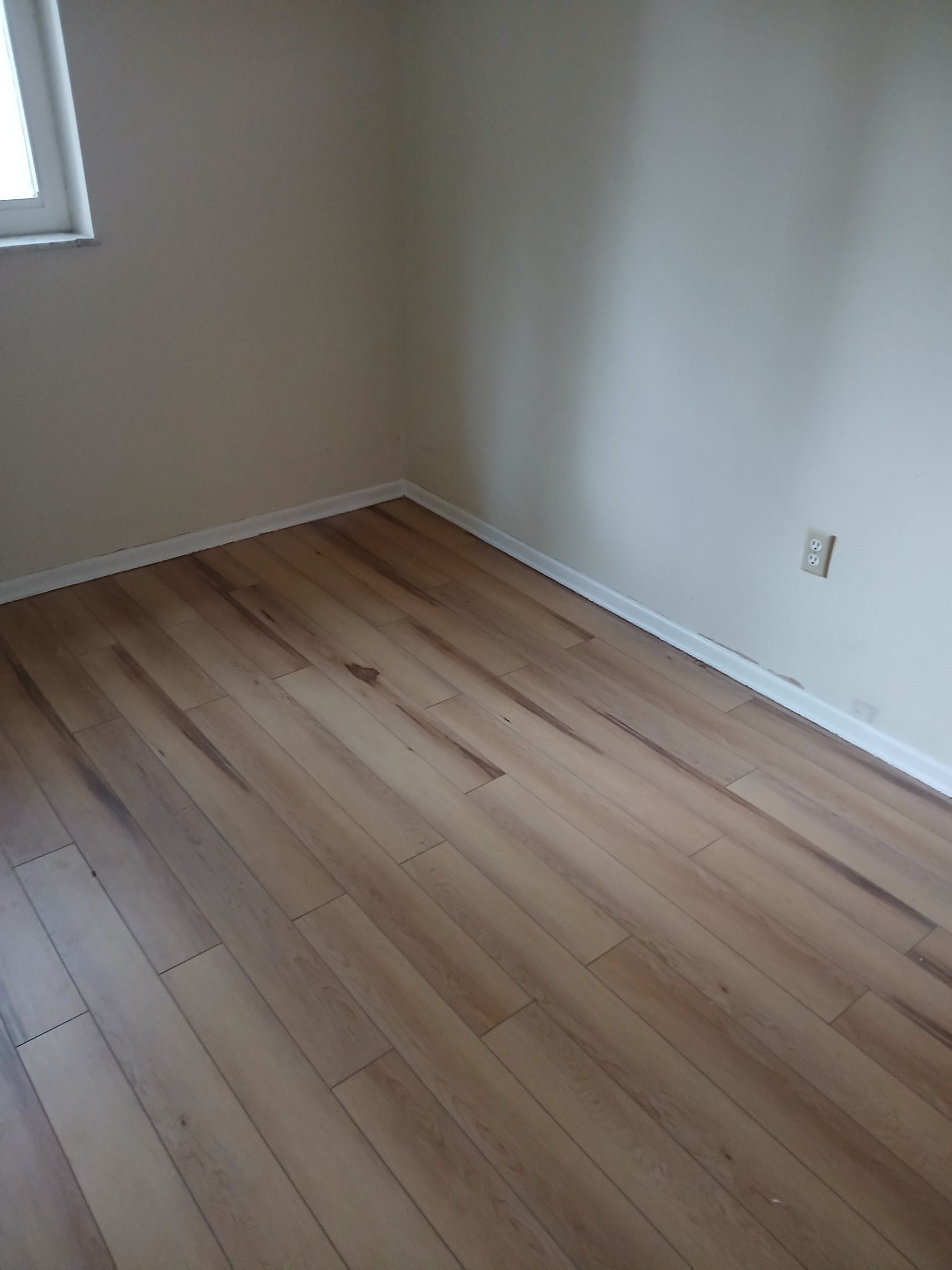 A room with a wooden floor and white walls.
