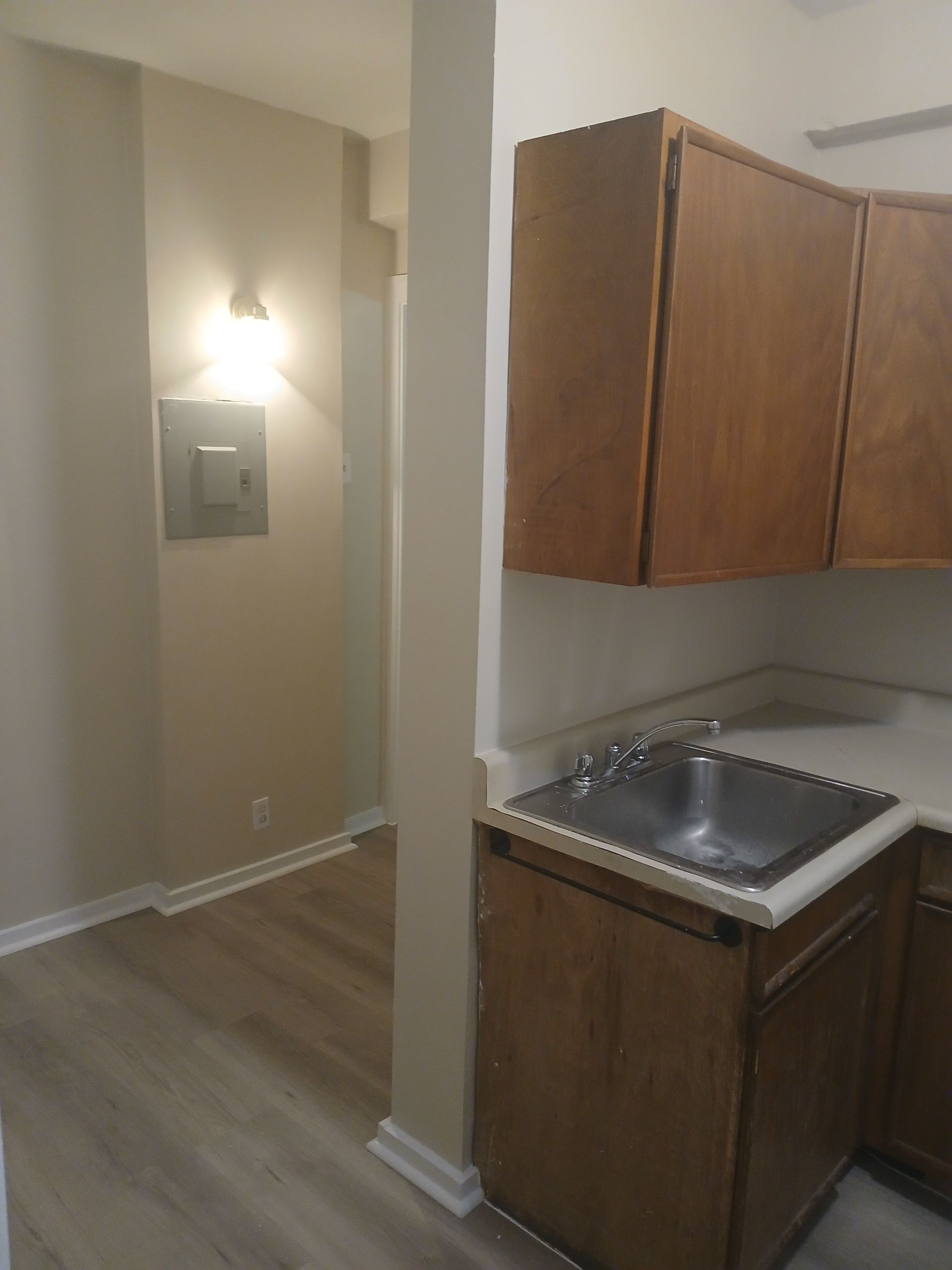 A kitchen with wooden cabinets and a stainless steel sink