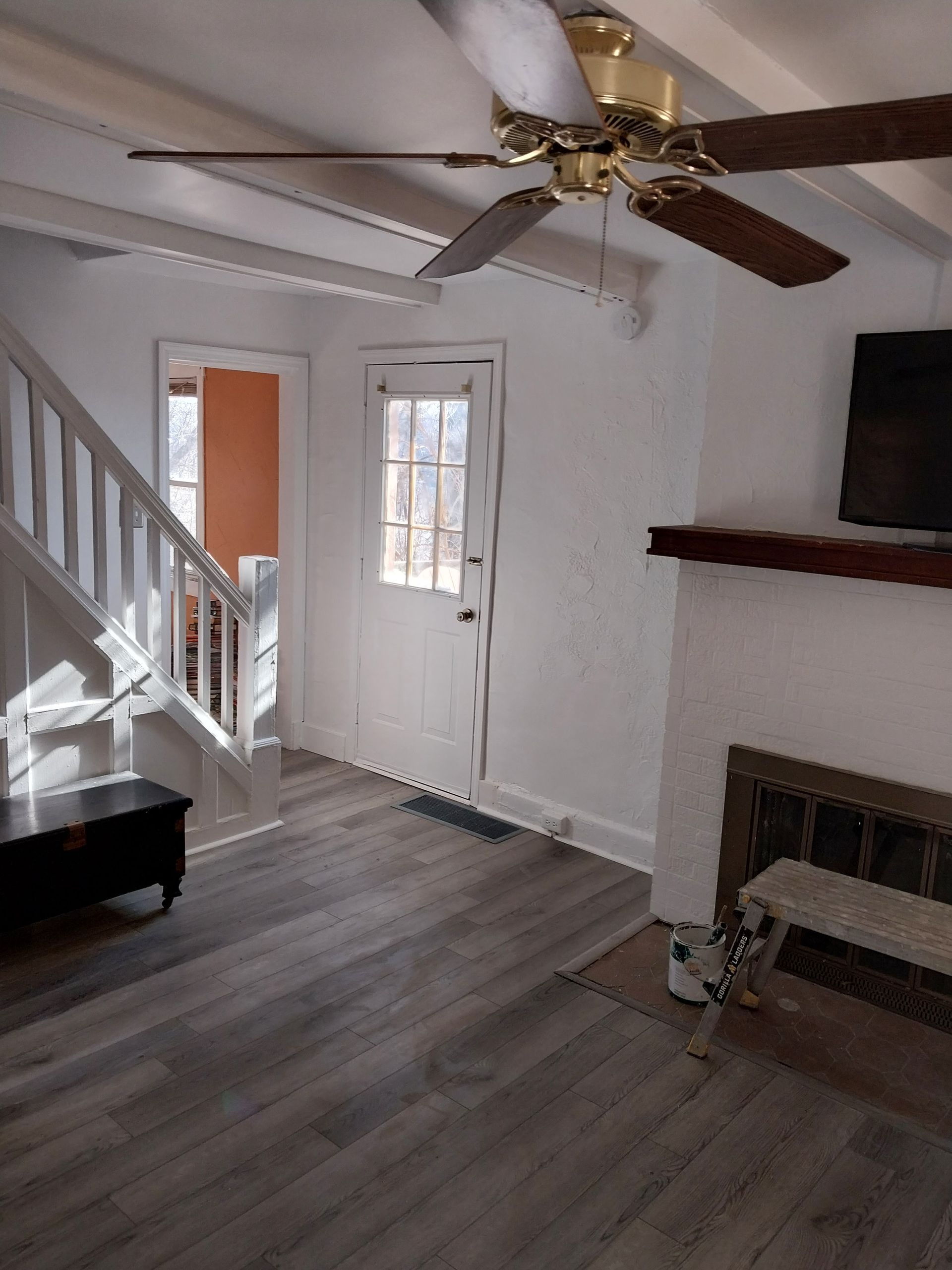 A living room with a ceiling fan and a fireplace