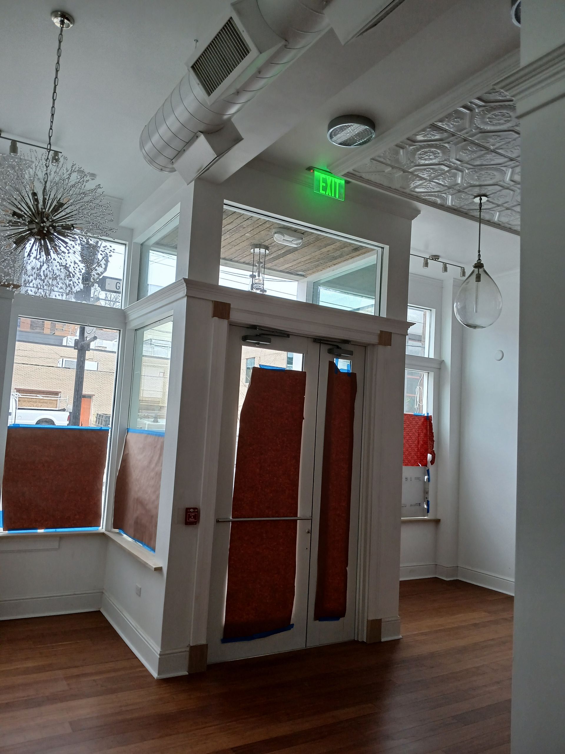 An empty room with a green exit sign on the ceiling