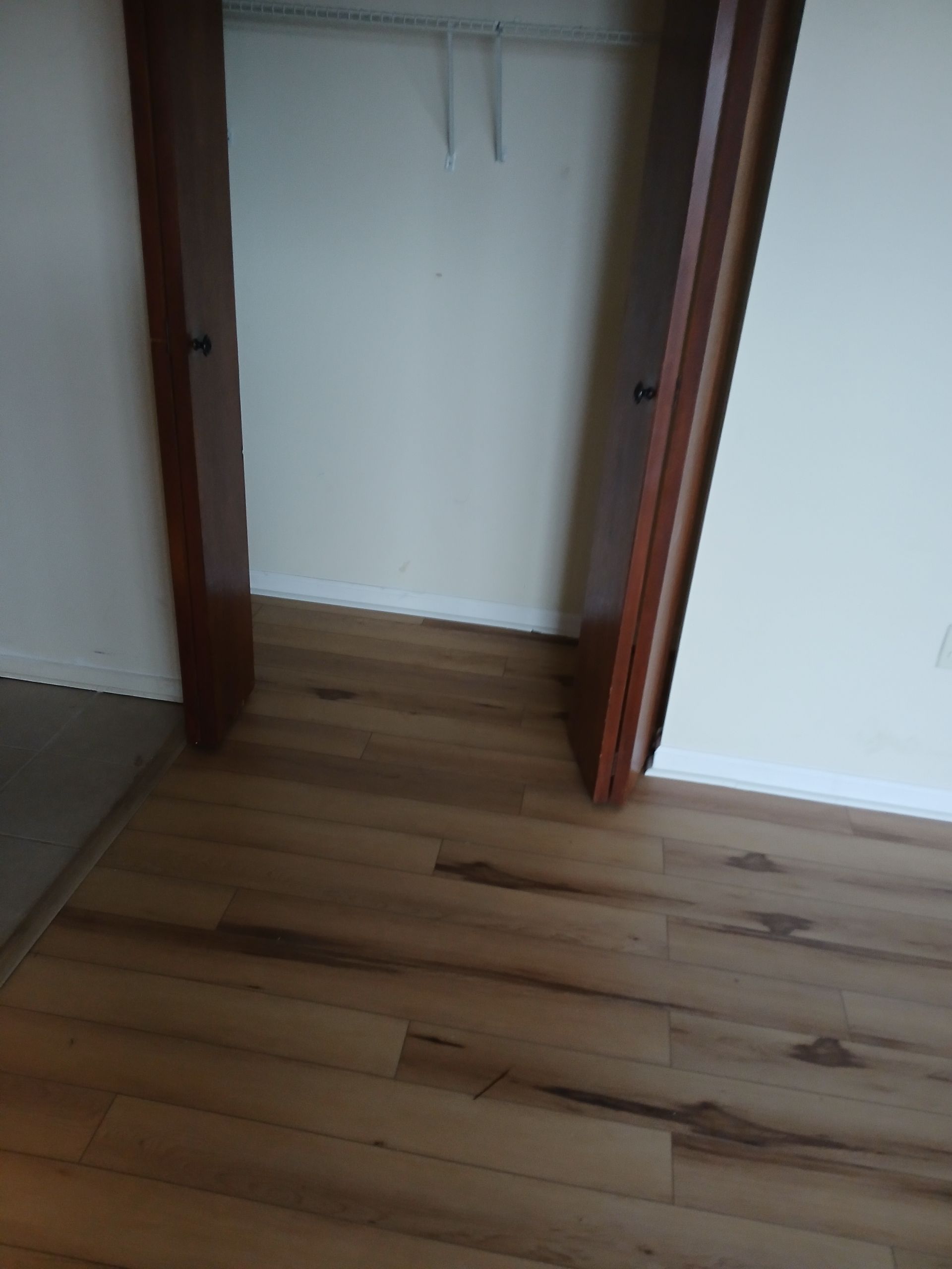 A closet with a wooden floor and a wooden door