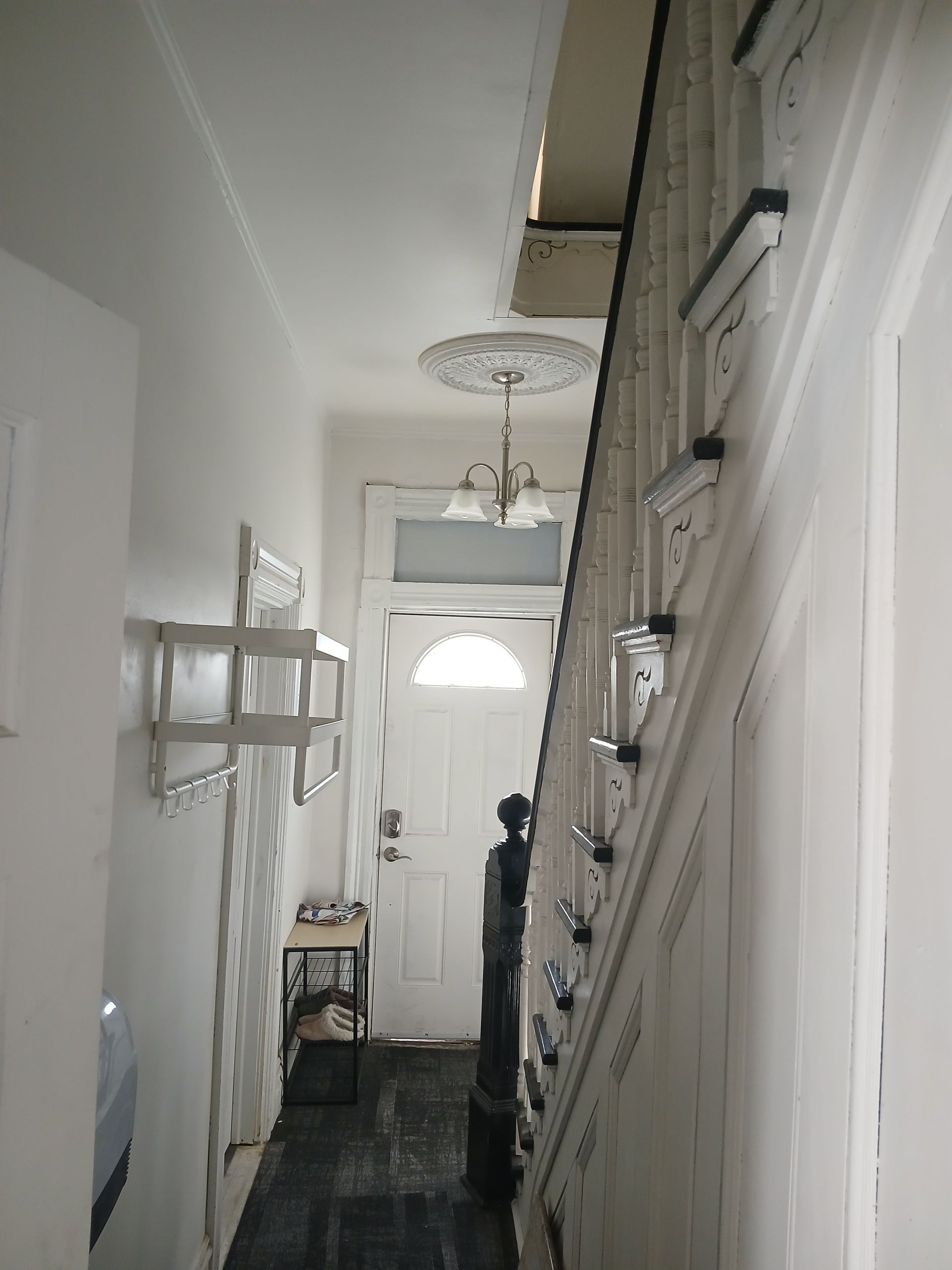 A hallway with stairs leading up to the second floor