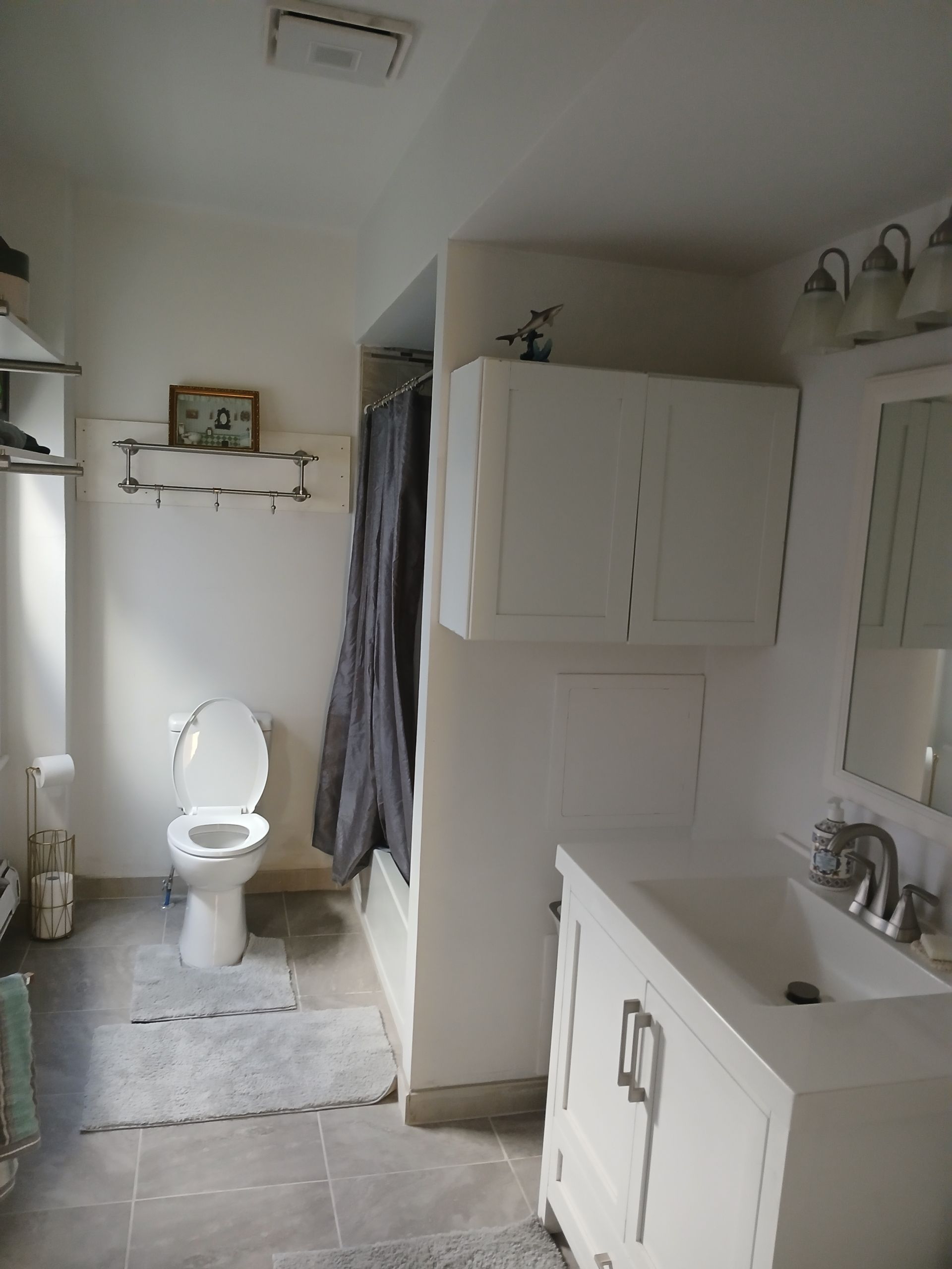 A bathroom with a toilet a sink and a mirror