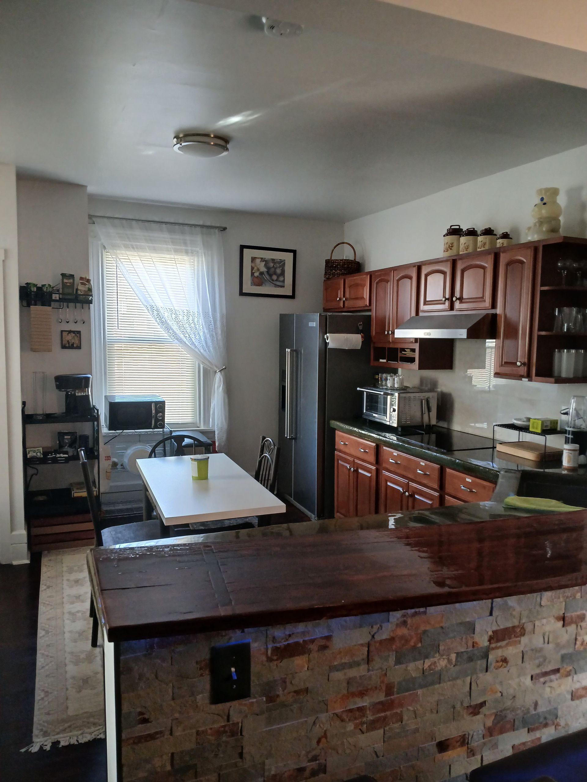 A kitchen with a table and a refrigerator in it