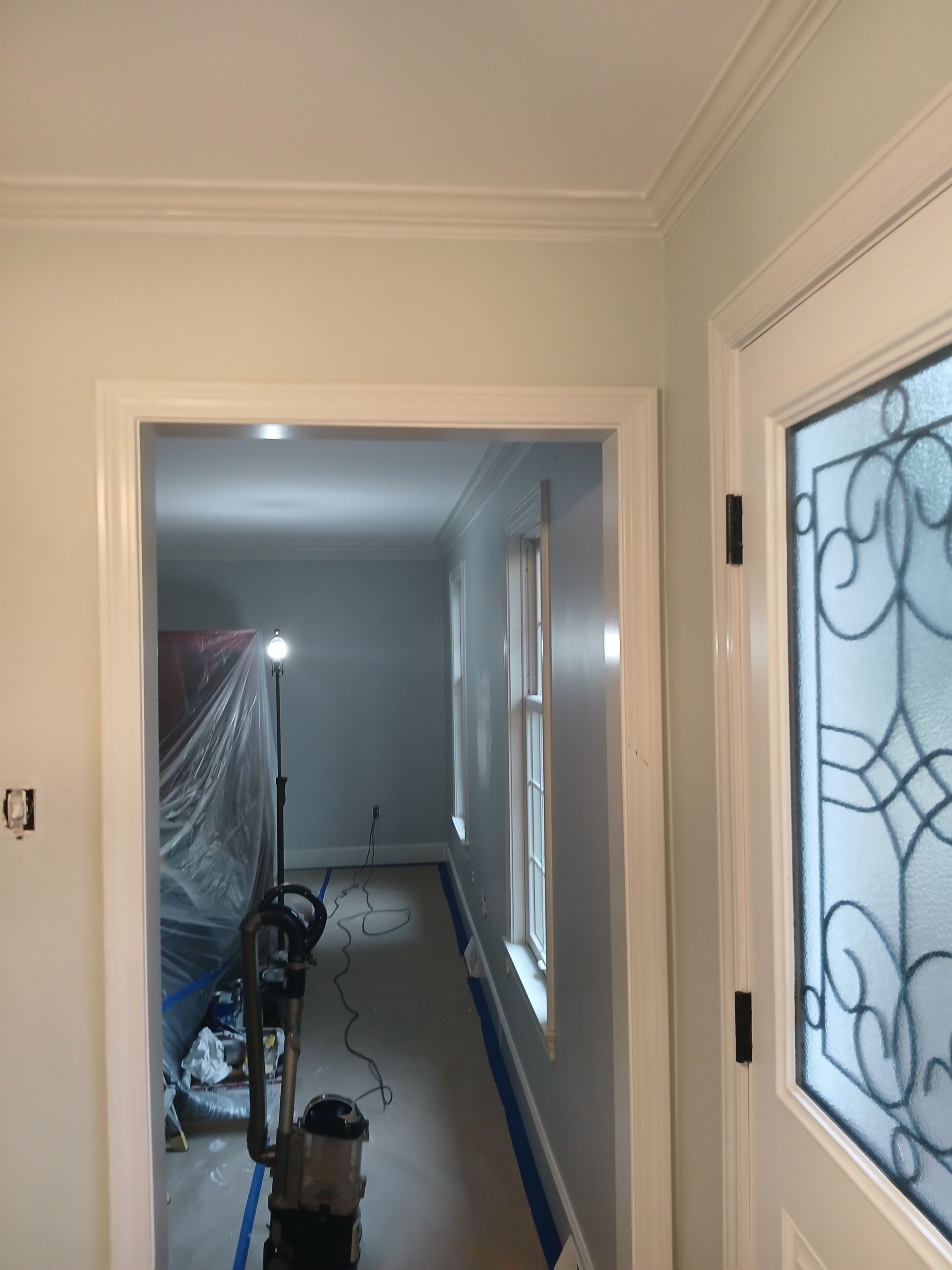 A doorway leading to a room with a vacuum cleaner in it.