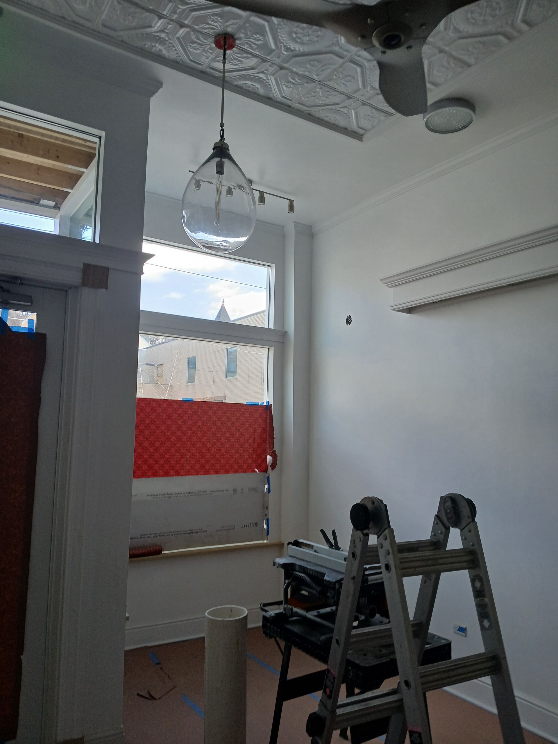 A room with a window and a ladder in it