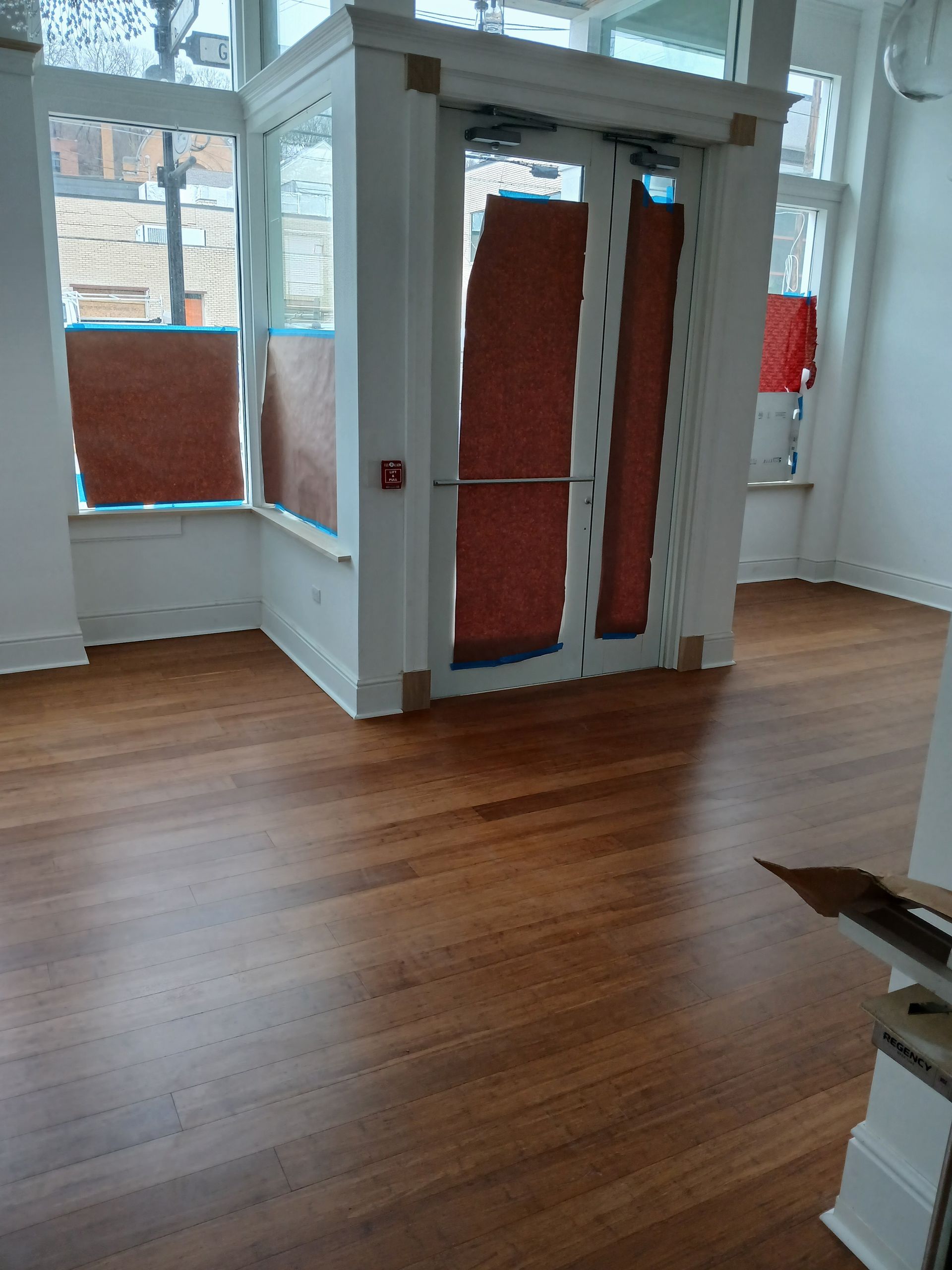 An empty room with a wooden floor and a door.
