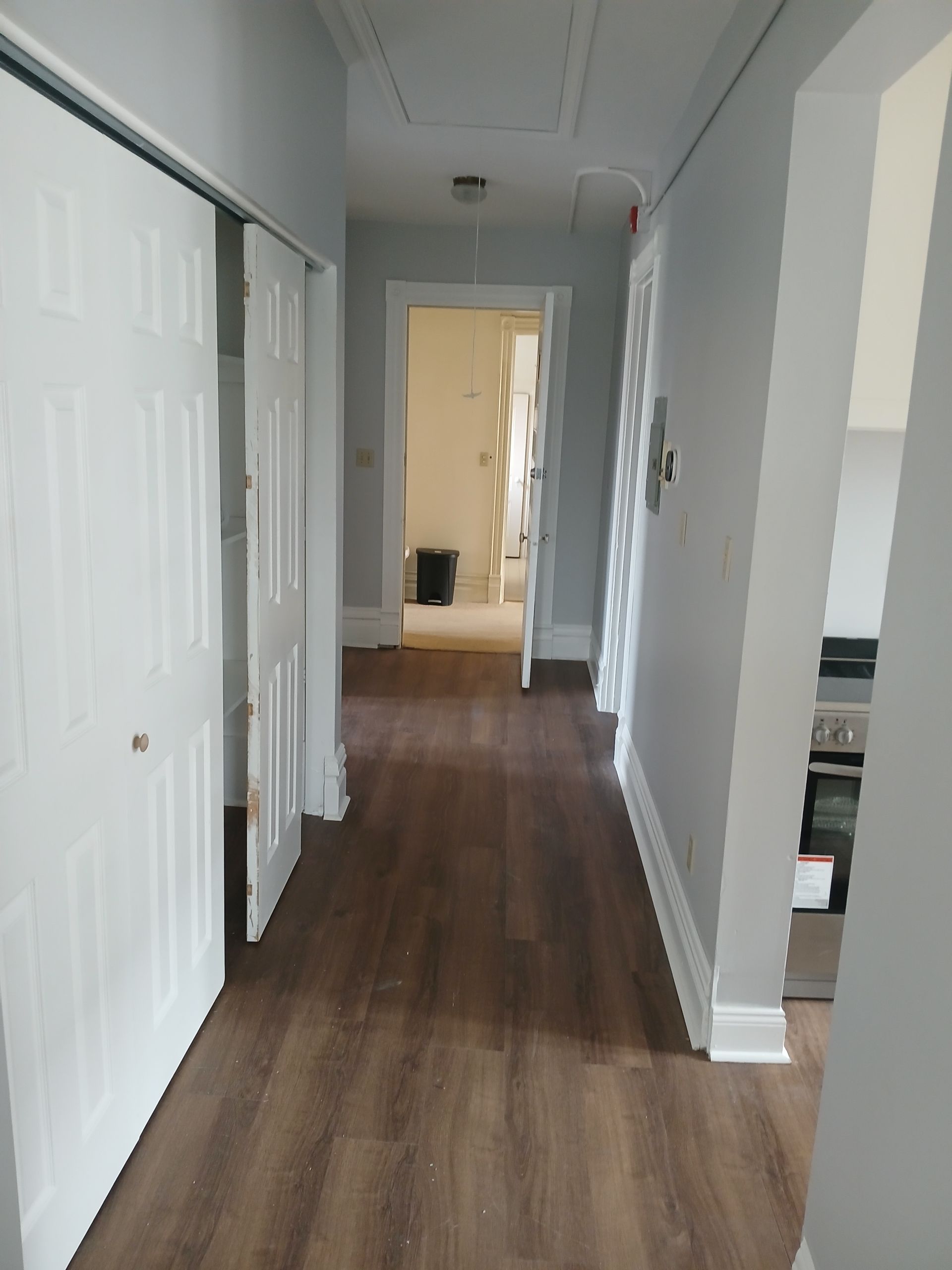 A hallway with hardwood floors and white walls