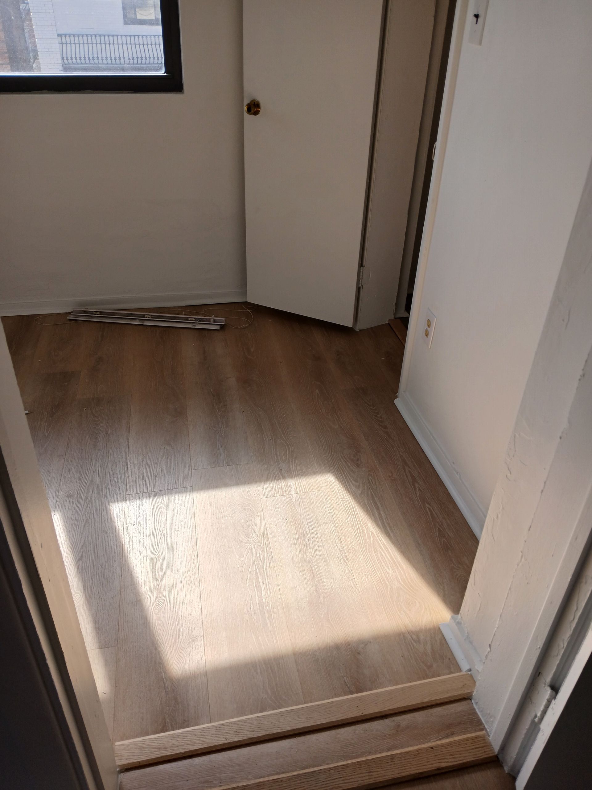 A room with hardwood floors and a window.