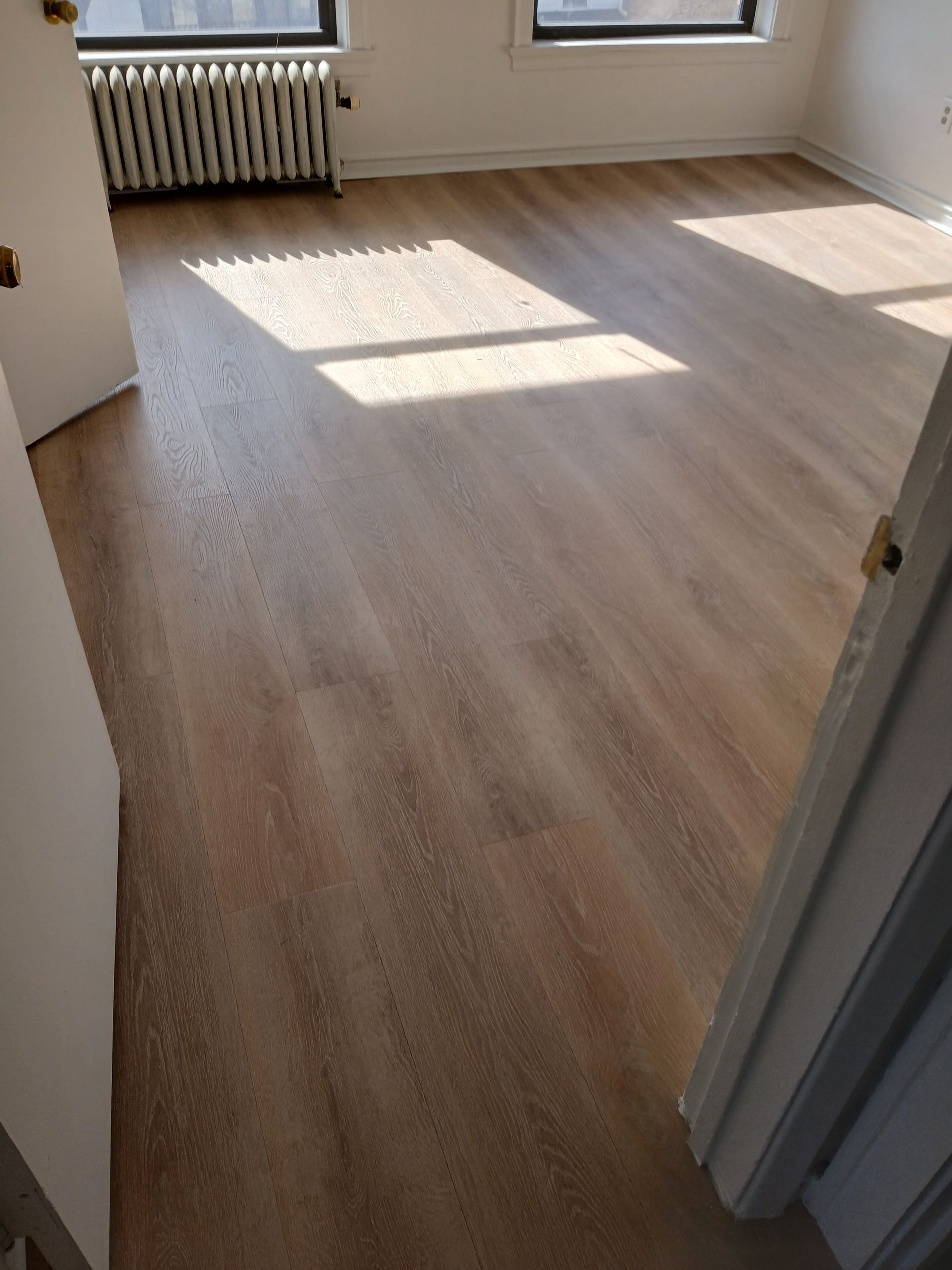 A room with a wooden floor and a radiator.