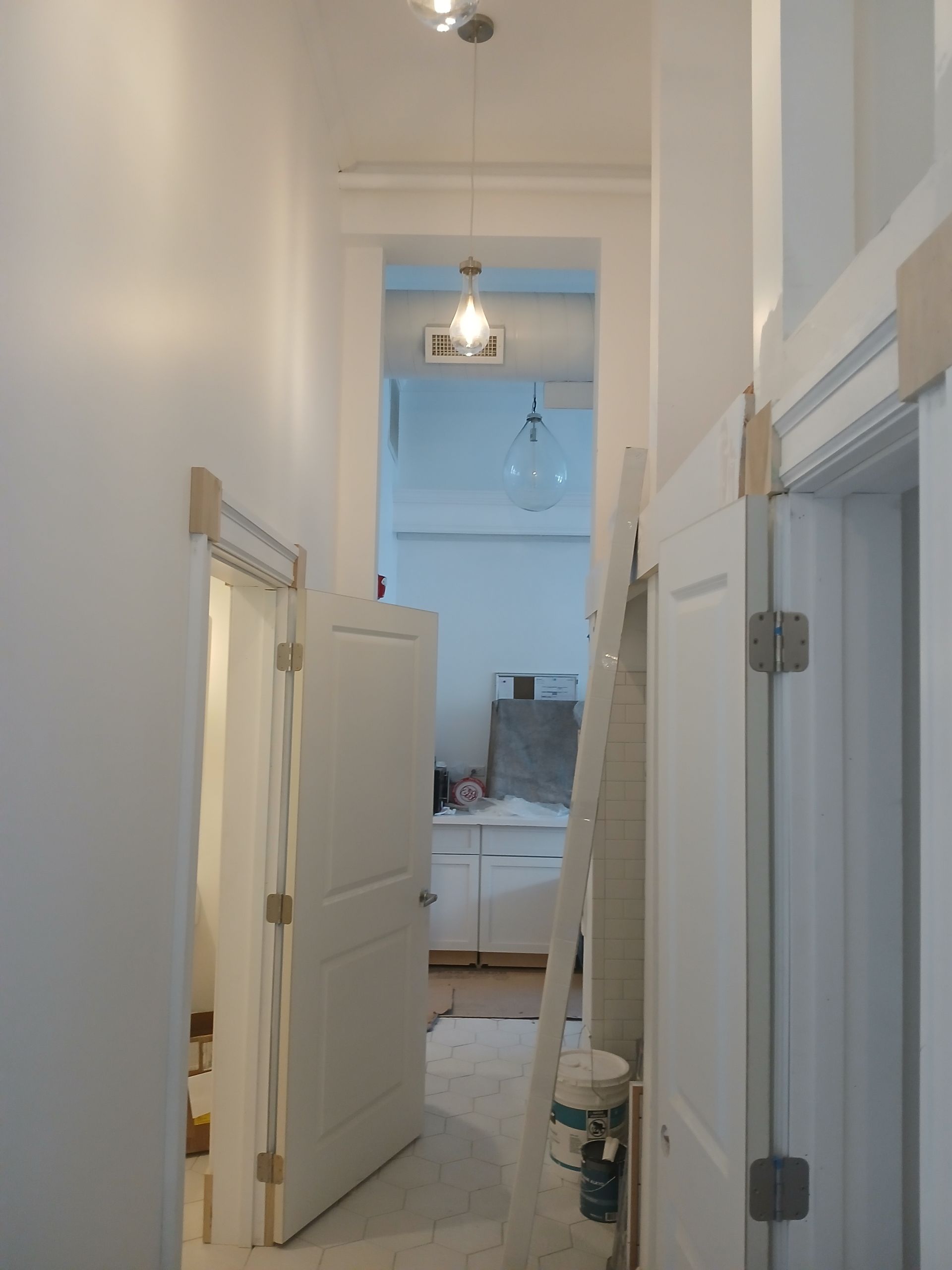 A hallway with a ladder leading up to a bedroom