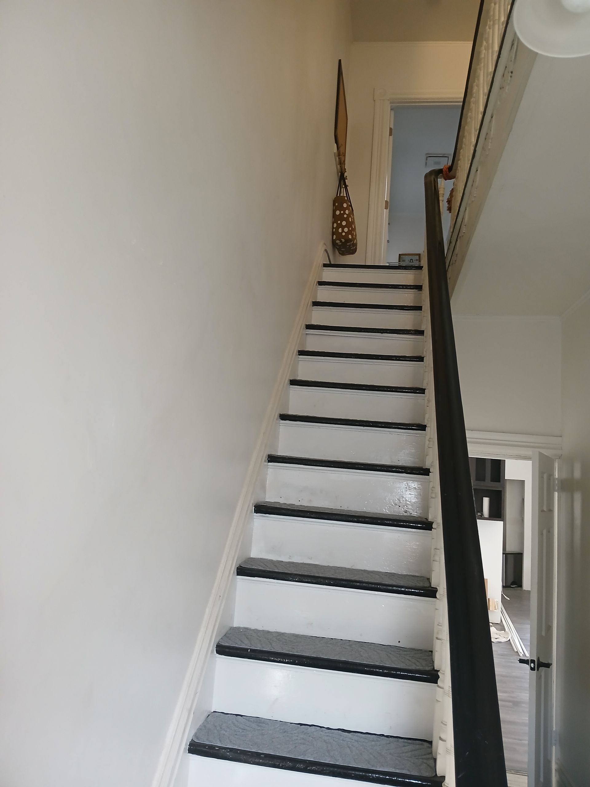 A white staircase with black steps and a black railing