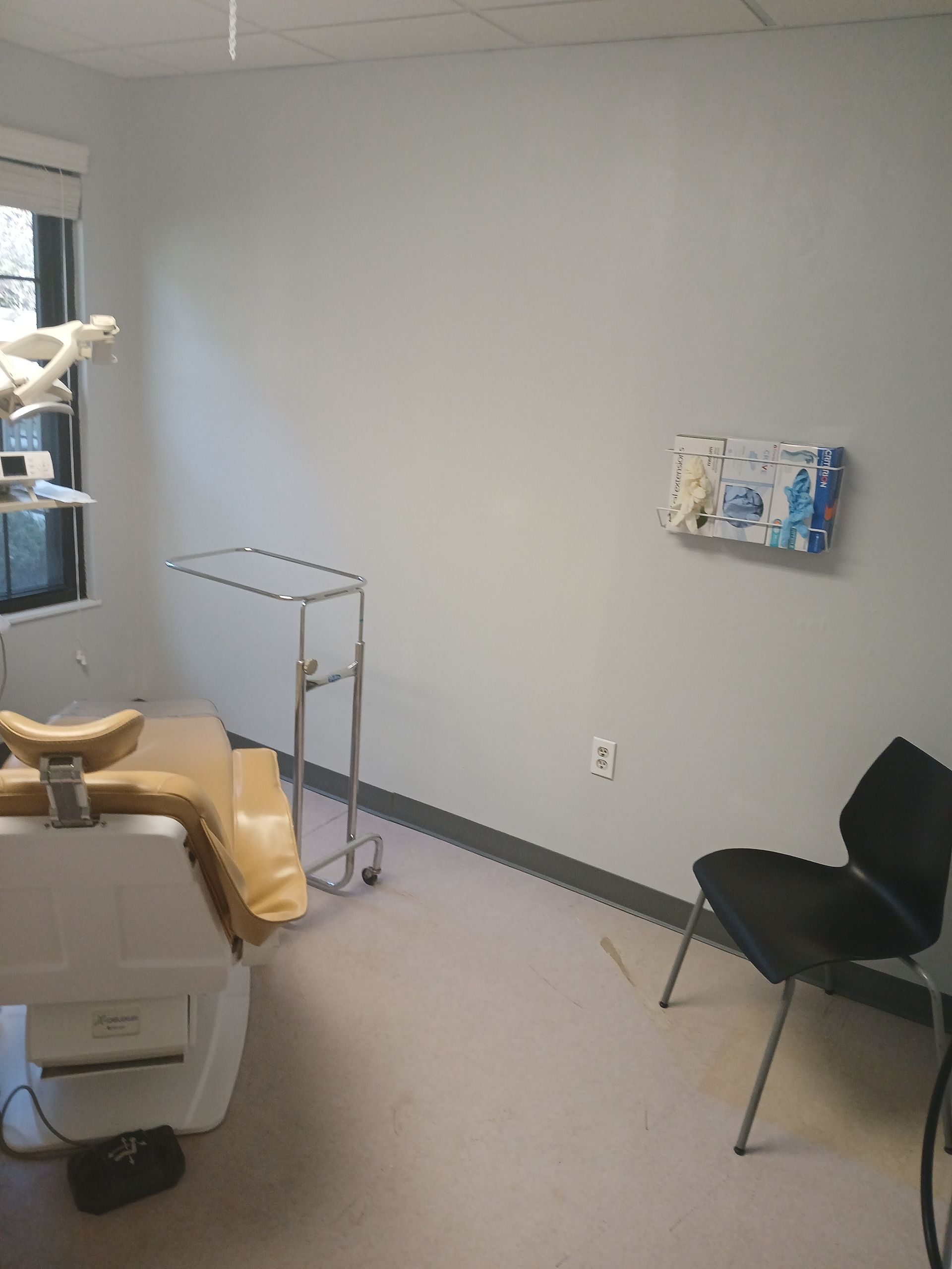 A dental office with a chair and a dental chair