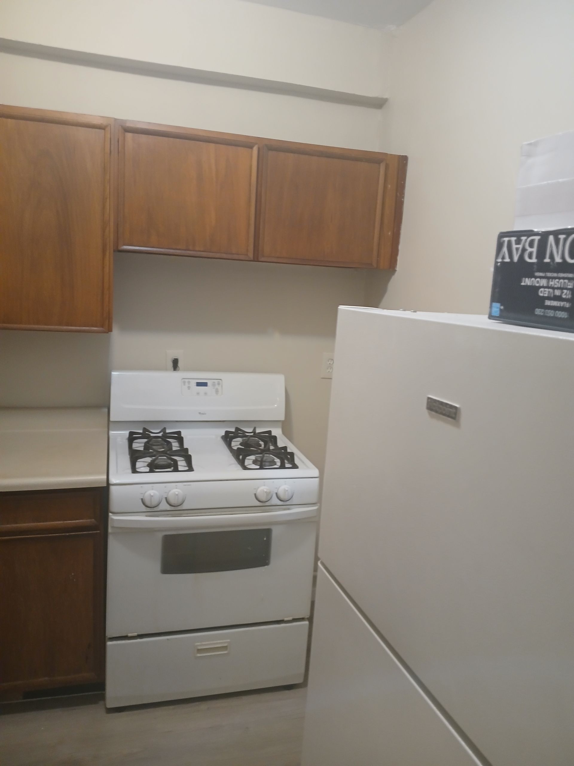 A kitchen with a stove top oven and a refrigerator