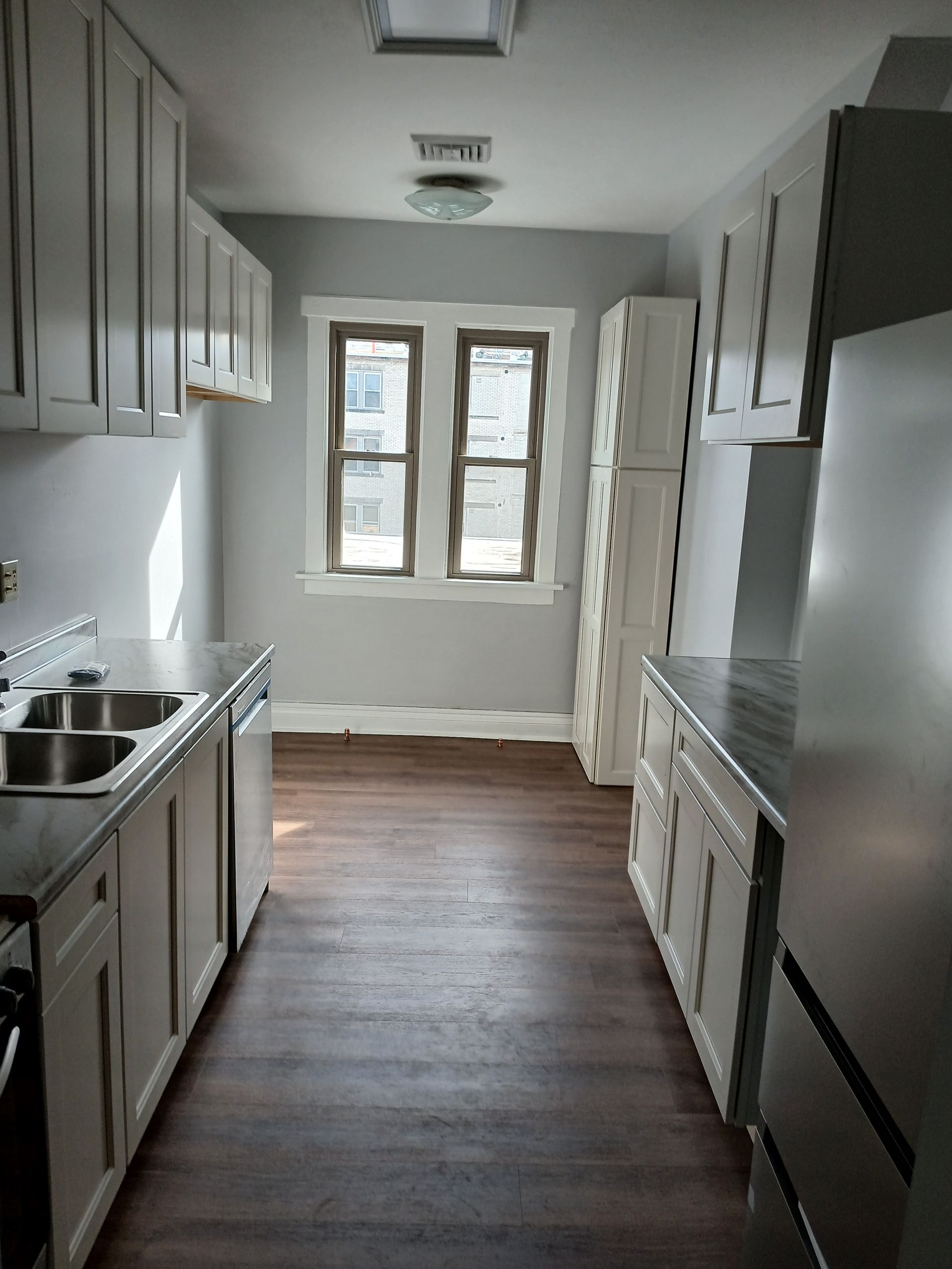 A kitchen with white cabinets and stainless steel appliances