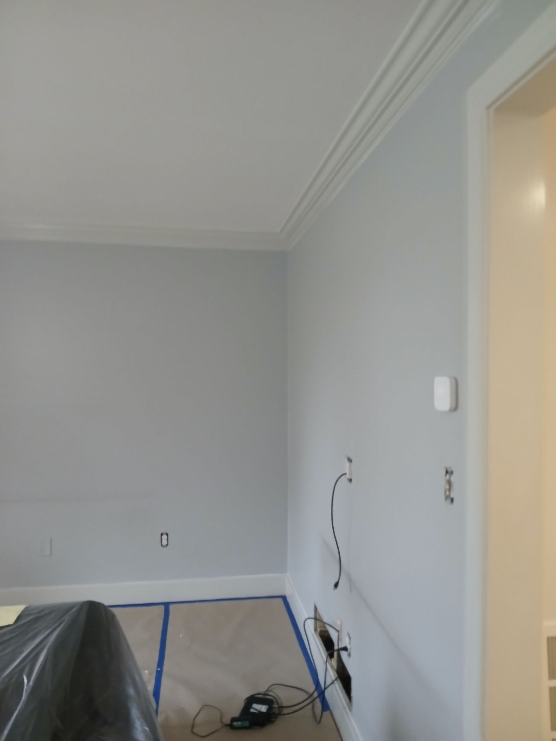 A room with white walls and blue tape on the floor