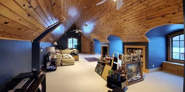 A living room with a wooden ceiling and blue walls