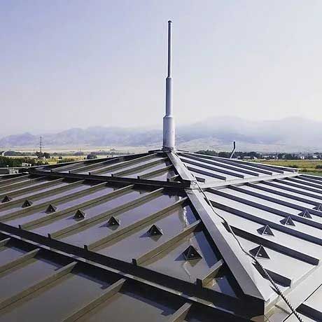 A metal roof with a lightning rod on top of it.