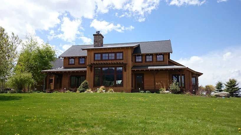 A large house is sitting on top of a lush green field.