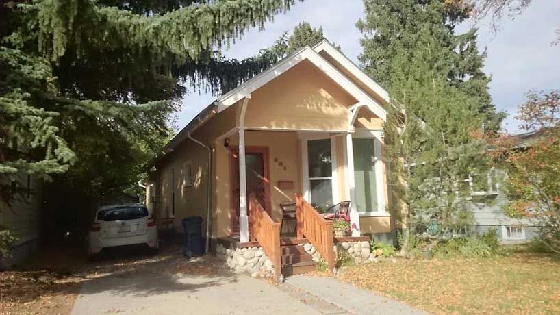 A small house with a car parked in front of it.