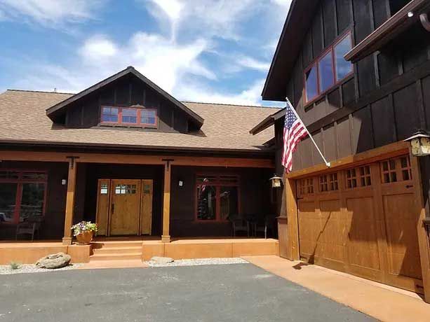 A large house with a garage and an american flag in front of it
