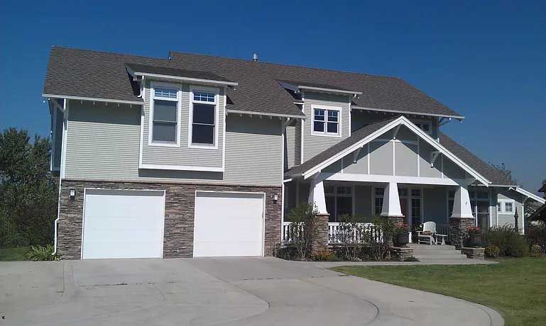 A large house with two garage doors and a porch