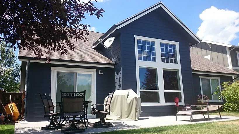 A blue house with a patio and a grill