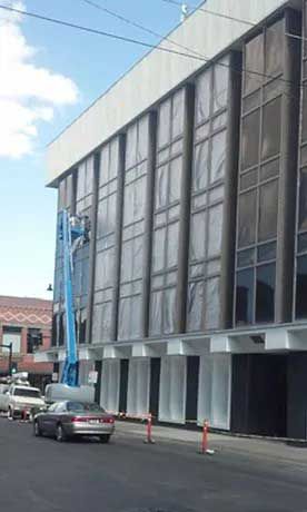 A large building with a lot of windows is being painted.