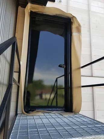 A door is sitting on top of a metal staircase next to a building.