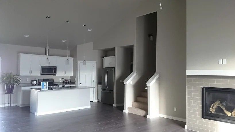 A kitchen in a house with a fireplace and stairs