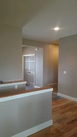 A living room with hardwood floors and a door.