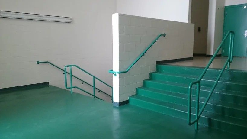 A staircase with green steps and a green railing