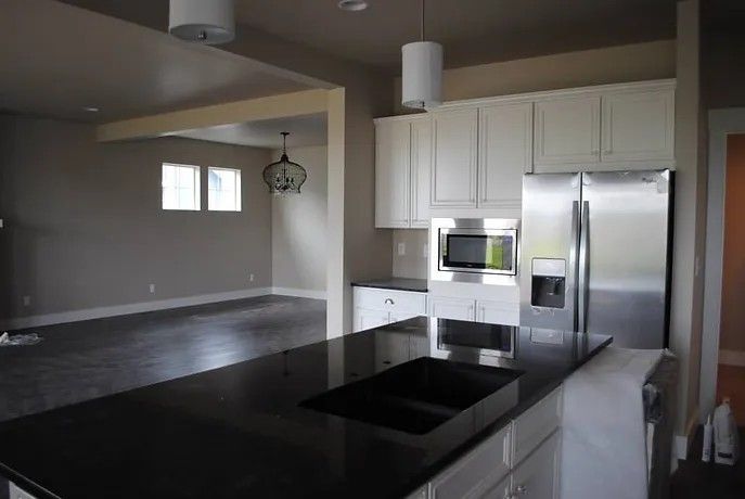 A kitchen with stainless steel appliances and white cabinets