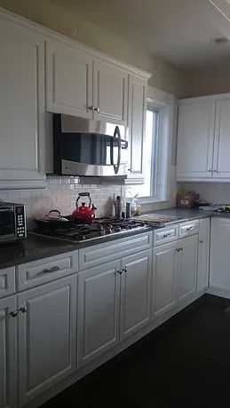 A kitchen with white cabinets and stainless steel appliances.
