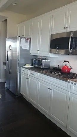 A kitchen with white cabinets and stainless steel appliances
