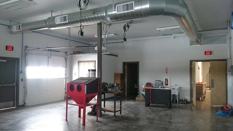 A large empty room with a red machine in the middle of it.