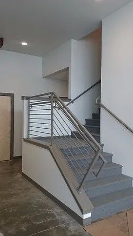 A staircase with a stainless steel railing in a building.