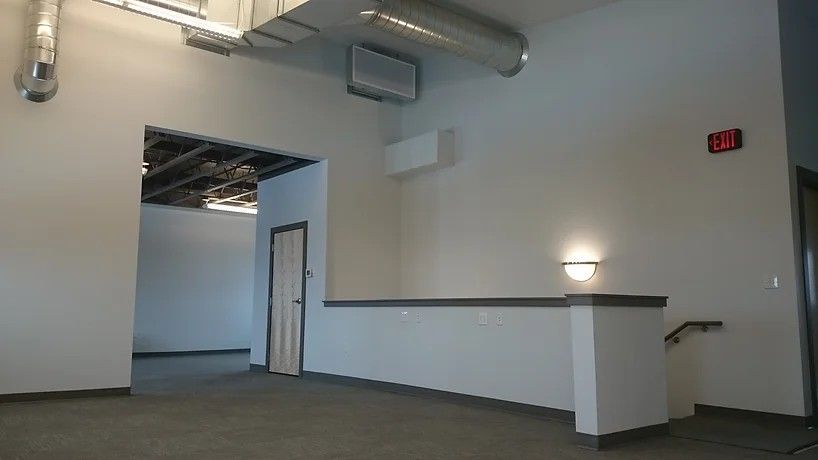 An empty room with a red exit sign on the wall