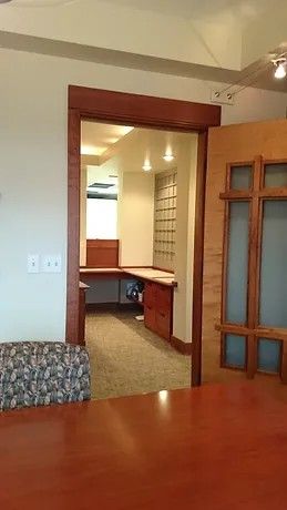A room with a table and chairs in it and a doorway leading to another room.